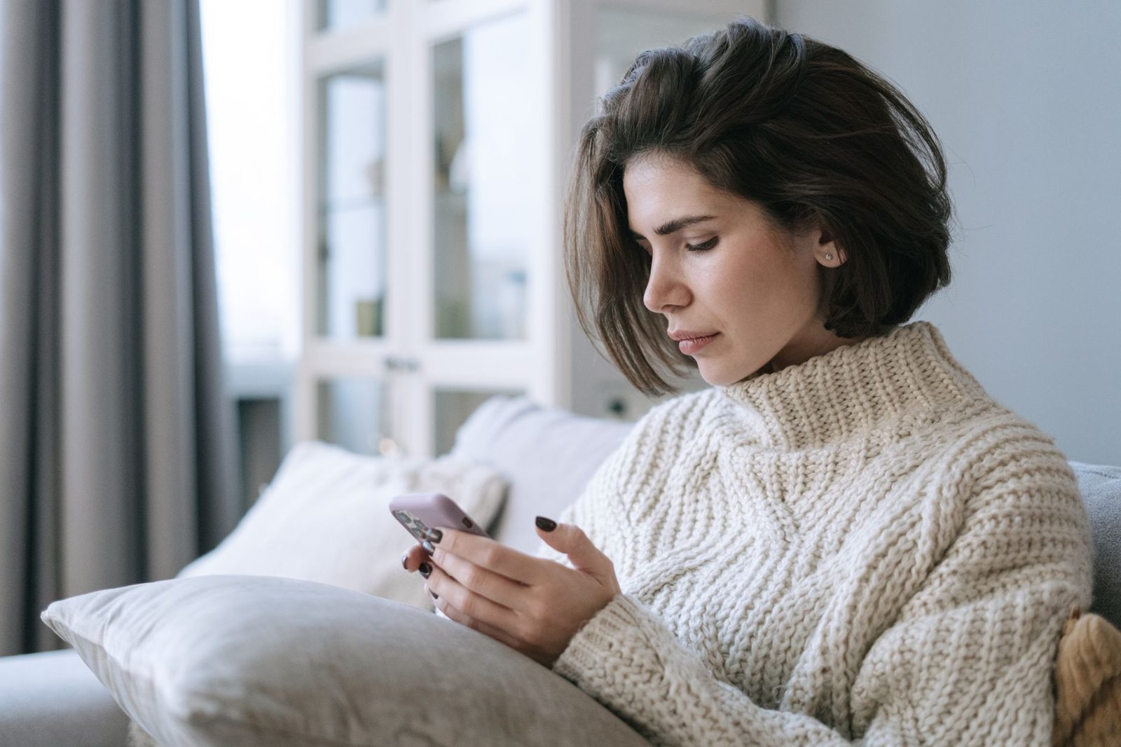 Woman reading a message on her phone in bed