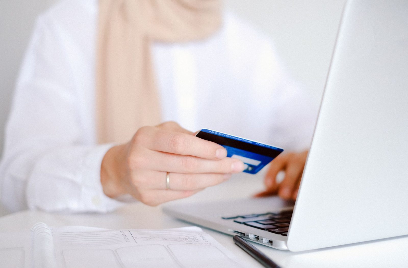 Bank card held over a laptop